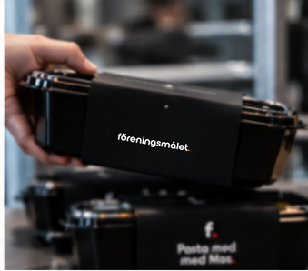 Staplade matlådor med Föreningsmålets svarta sleeve lyfts ur matlagret