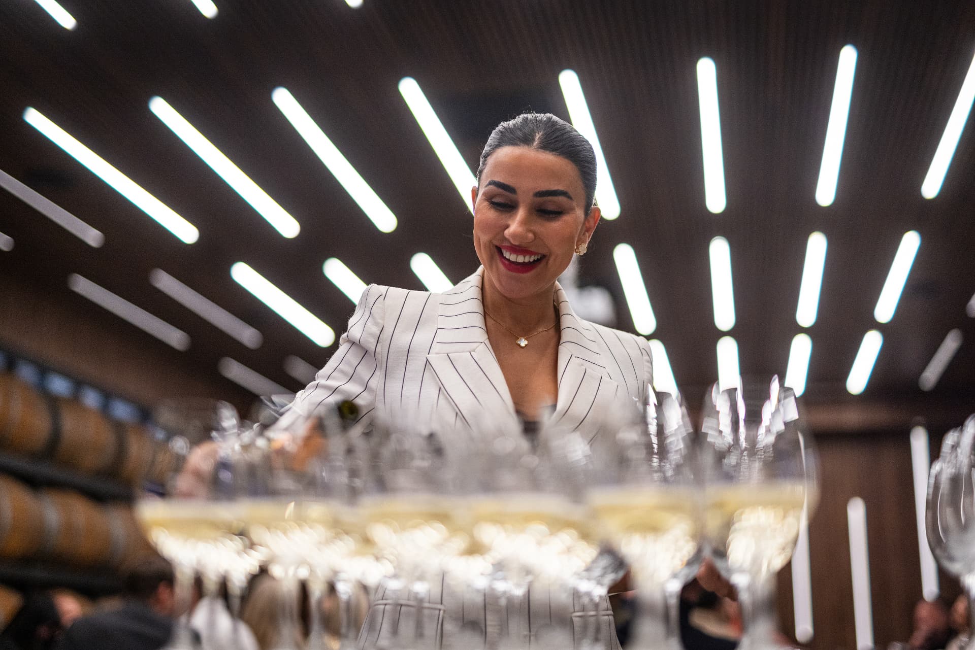 Värdinna serverar glas med mousserande vin under en afterwork